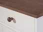 Armoire blanche avec un dessus en bois brun foncé.