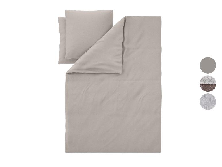 Parure de lit gris clair avec oreillers et échantillons de tissu.