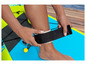 Une personne met une sangle de cheville noire sur un paddleboard gonflable.