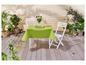 Une nappe verte sur une table en bois avec deux chaises blanches.