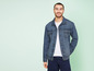Un homme portant une veste en jean et un t-shirt blanc.