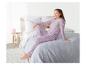 Une fille en pyjama à étoiles assise sur un lit.