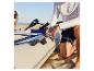 Un homme prépare un bateau gonflable HOME DELUXE Pike Eco sur une plage de sable.