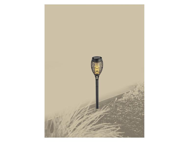 Lampe solaire de jardin à effet flamme dans un parterre.
