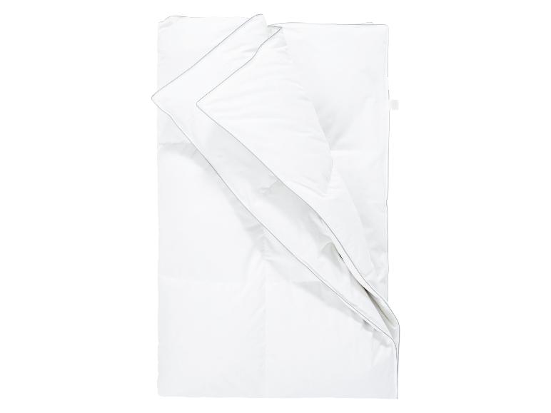 Une couette blanche et deux taies d'oreiller avec une bordure grise.
