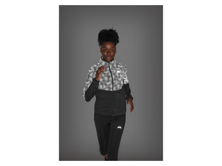Femme en tenue de sport noire et grise réfléchissante, prête à courir.