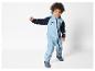 Un enfant portant une combinaison bleue avec un motif de tigre.
