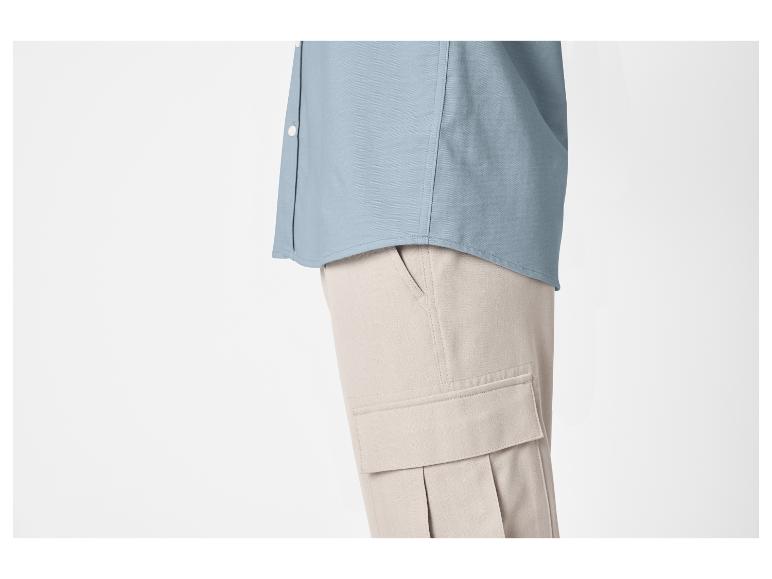 Chemise bleue et pantalon cargo beige pour homme.