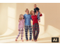 Famille heureuse en pyjamas à carreaux assortis, la maman tenant le bébé.