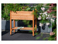 Une jardinière en bois avec des fleurs et une paire de gants de jardin.