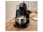 Robot pâtissier noir avec bol en acier inoxydable rempli de blancs d'œufs sur un comptoir de cuisine.