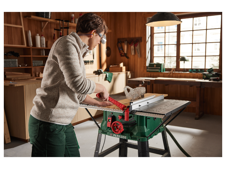 Une femme utilise une scie à table Parkside dans son atelier.