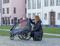 Une femme et un enfant dans une remorque à vélo Qeridoo se donnent un high five.