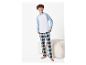Garçon modelant un pyjama confortable avec un haut rayé bleu et blanc et un pantalon à carreaux.