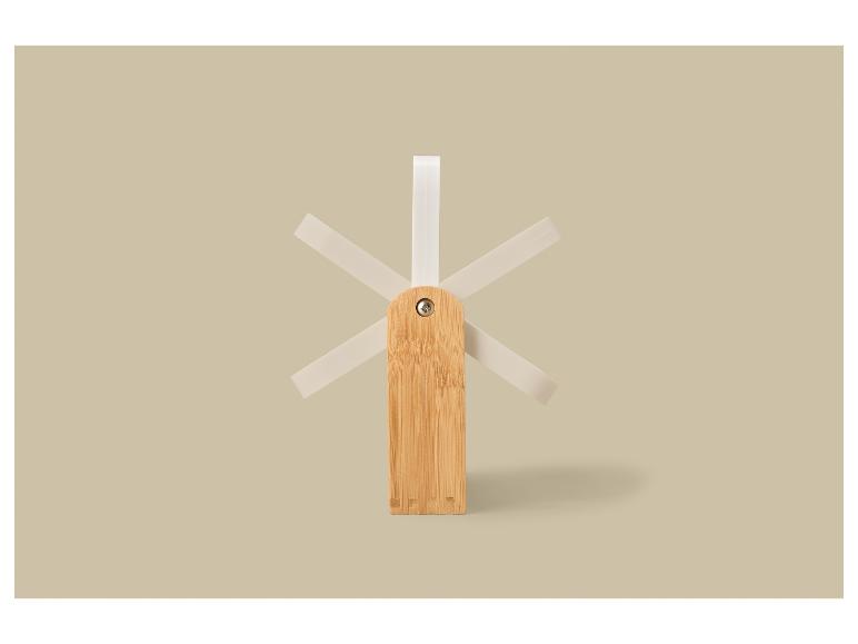 Égouttoir à vaisselle en bois avec des chevilles blanches sur fond beige