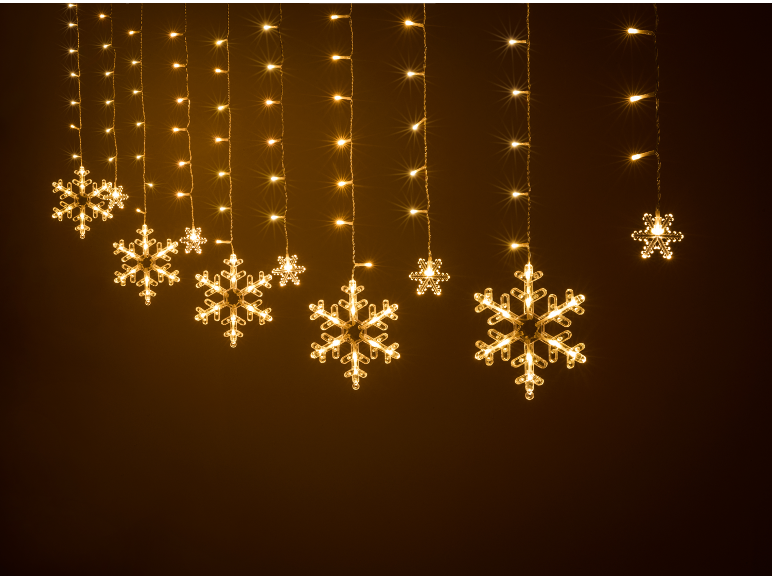 Guirlande lumineuse flocons de neige blanc chaud sur fond sombre.