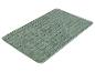 Un tapis de bain vert à carreaux.