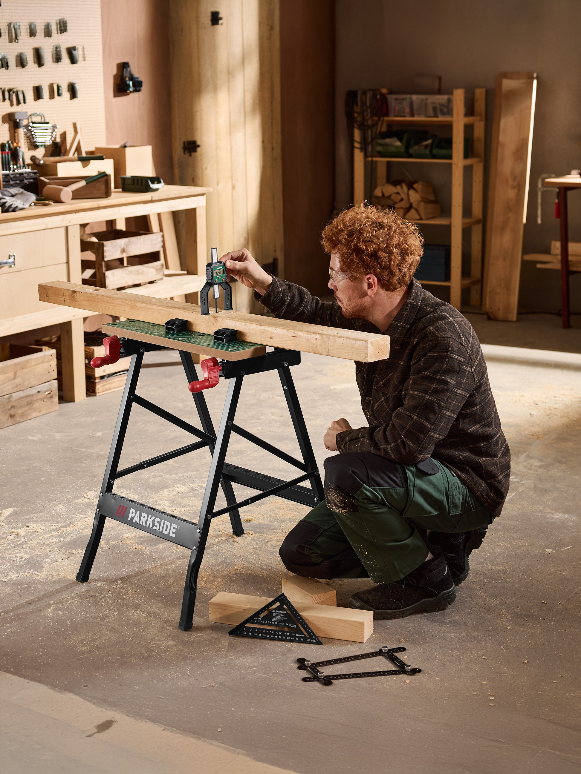 Homme mesurant du bois sur un établi noir PARKSIDE avec une jauge de profondeur numérique.