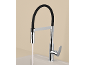 Robinet de cuisine moderne avec tuyau flexible noir et eau courante dans un évier.