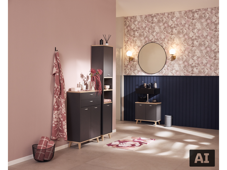 Salle de bain moderne avec meubles gris, lavabo noir, miroir rond et papier peint floral.