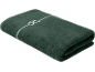 Serviette pliée vert foncé avec un motif décoratif blanc.