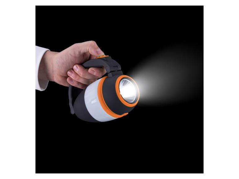 Main tenant une lampe de poche noire et orange avec un faisceau lumineux.