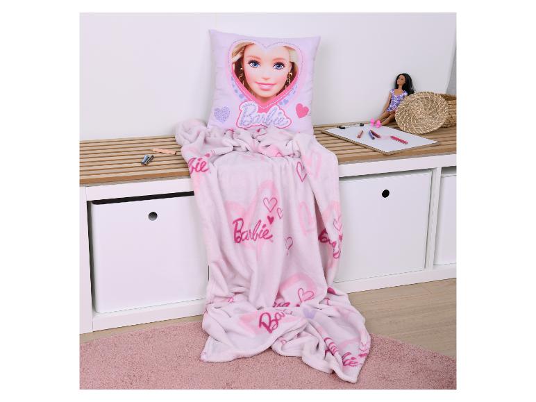 Coussin et couverture Barbie roses sur un banc de rangement avec une poupée et des crayons.