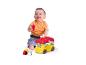 Un bébé joue avec un bus Clementoni Disney Baby et des blocs.