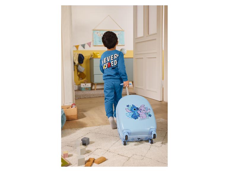 Enfant en survêtement bleu avec Stitch et Angel tirant une valise bleu clair.