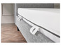 Un sommier gris avec un matelas blanc.
