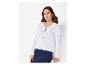 Une femme porte un cardigan blanc en tricot avec des boutons.