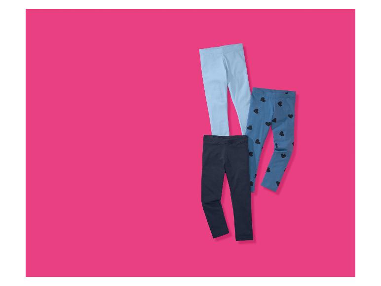 Trois paires de leggings pour enfants : bleu clair, bleu foncé et bleu avec des cœurs noirs.