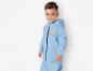 Un jeune garçon porte un imperméable bleu avec un imprimé tigre.