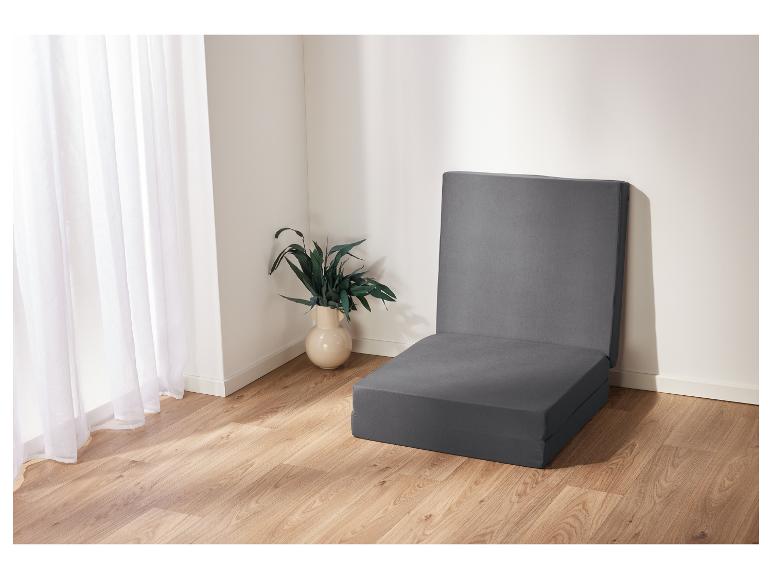 Matelas pliable gris dans une pièce claire.