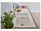 Évier de cuisine blanc avec robinet chromé et plan de travail en bois.