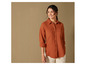 Une femme porte une chemise orange à boutons.