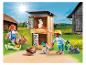 Figurines Playmobil d'enfants nourrissant des lapins dans un clapier à la ferme.