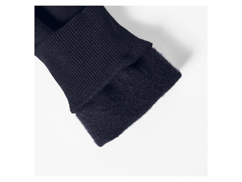 Gros plan d'un poignet de pull bleu foncé avec tricot côtelé et doublure douce