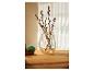 Un vase avec des branches de saule et un œuf de Pâques sur une table en bois.