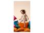 Enfant joyeux sautant sur des coussins colorés, vêtu d'une tenue à cœurs.