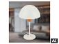 Lampe de table blanche avec base ronde et abat-jour en forme de dôme, dans une chambre floue.