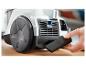Aspirateur avec une main tenant une buse étroite.