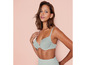 Une femme porte un soutien-gorge et une culotte assortis de couleur gris clair.
