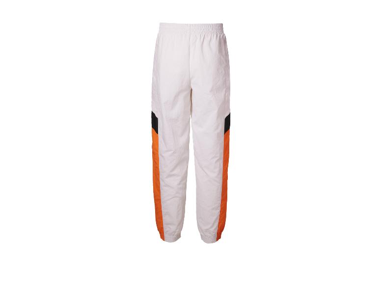 Pantalon de survêtement blanc avec bandes orange et noires.