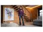 Fille en sweat à capuche bordeaux avec le texte 'PARIS AMOUR CLUB' et jean foncé, dans un salon moderne.