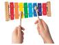Un enfant joue d'un xylophone coloré avec deux baguettes en bois.