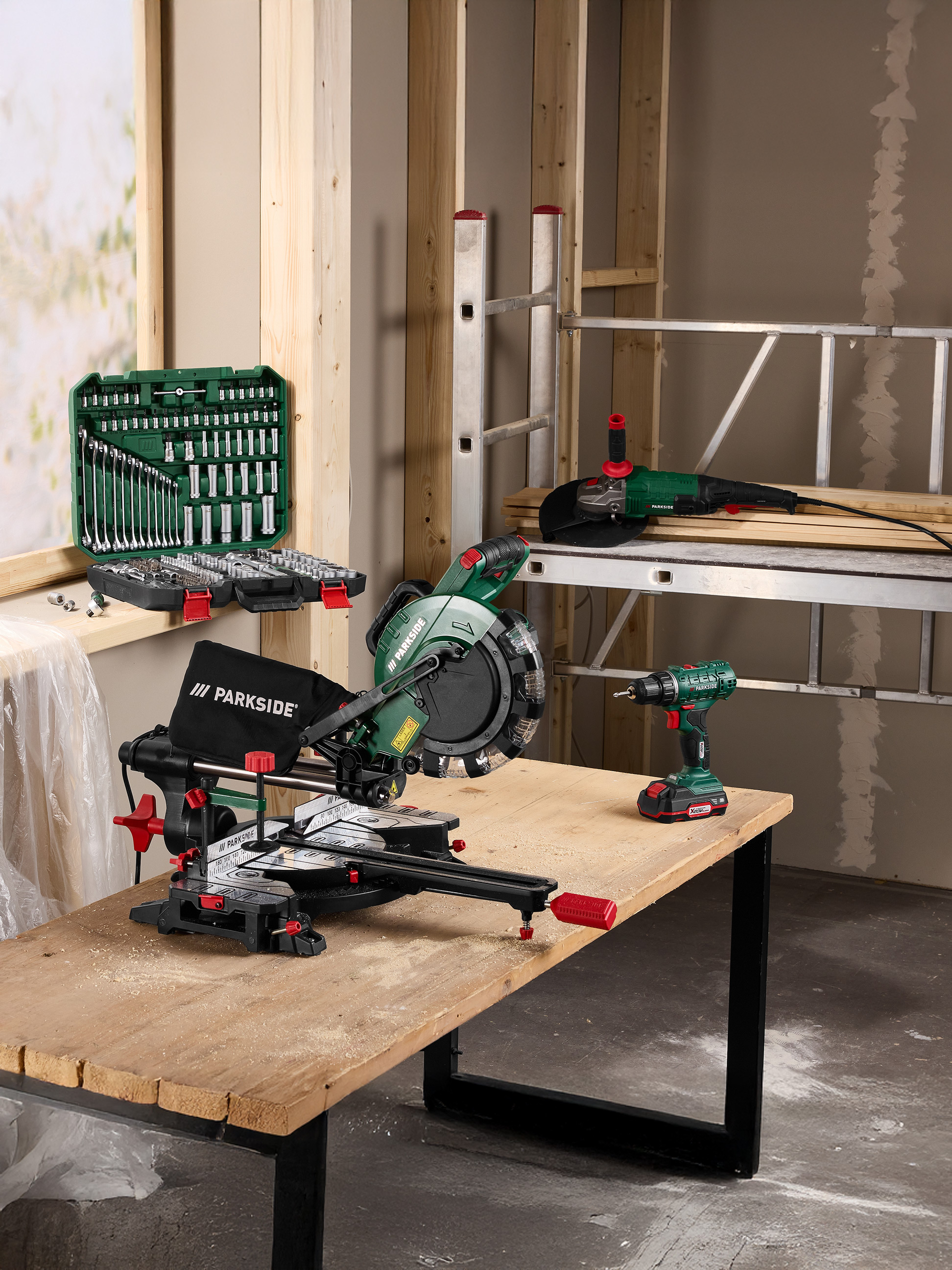 Outils de construction : scie, perceuse, meuleuse d'angle et jeu d'outils sur une table en bois.