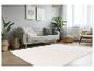 Tapis rectangulaire blanc cassé avec motif en relief dans un salon moderne et lumineux.