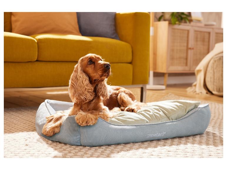 Un cocker spaniel se repose dans un lit pour chien ZooFarı bleu.