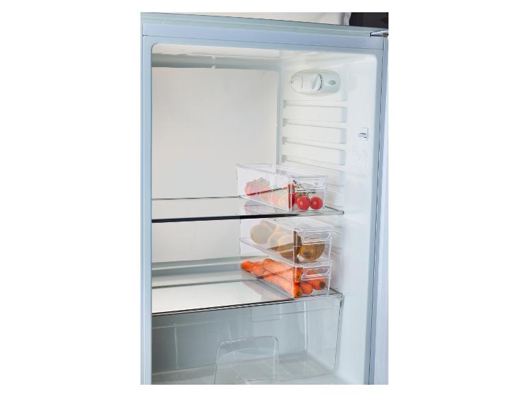 Réfrigérateur avec des contenants transparents remplis de tomates, kiwis et carottes.